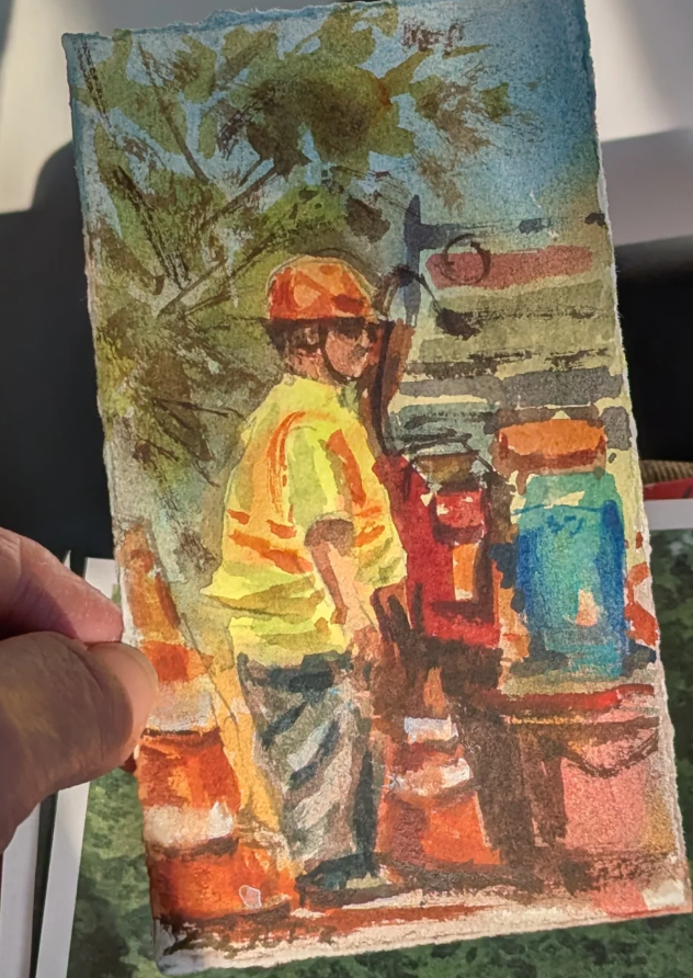 Patty holding an approximately 6 by 4 inch watercolor figure study with two workers